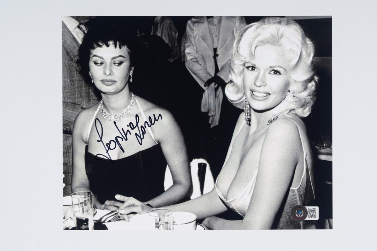 Lotto 100 Sophia Loren Foto autografata - 21,5x 20 cm (8”x10” inch) – Cert. Beckett Foto autografata da Sophia Loren con dimensioni 21,5x 20 cm (8”x10” inch) e certificata dalla Beckett.