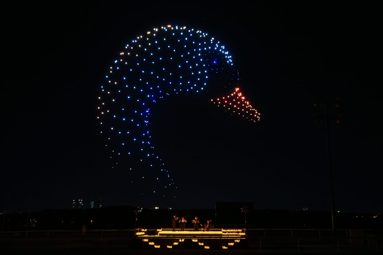 Visual della locandina di DroneArt Show con droni luminosi nel cielo notturno