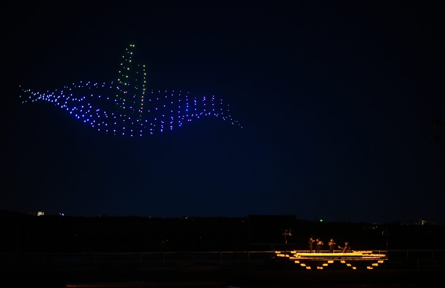 Coreografia di droni luminosi nel cielo durante DroneArt Show