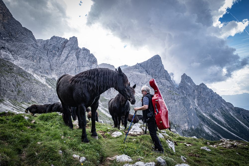 Escursionisti e musicisti durante un concerto de I Suoni delle Dolomiti in alta quota